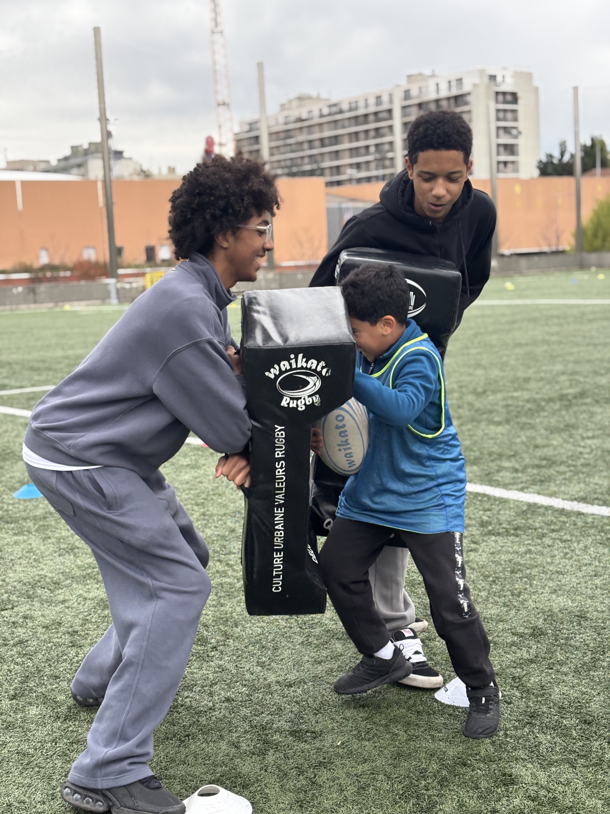Jeunes en séance de rugby avec éducateurs sur un terrain de Courbevoie